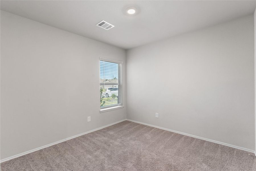 Secondary bedroom with carpet flooring and window. Secondary bedroom with carpet flooring and window.
