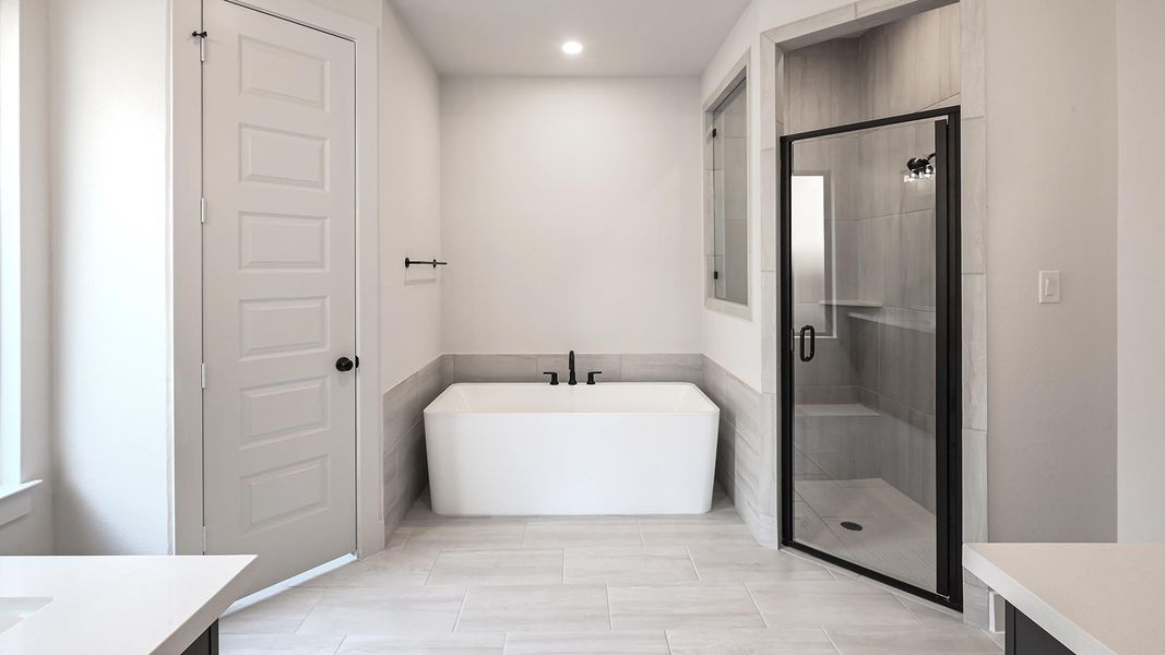 Bathroom with vanity, a freestanding bath, a shower stall, recessed lighting, and light tile patterned floors
