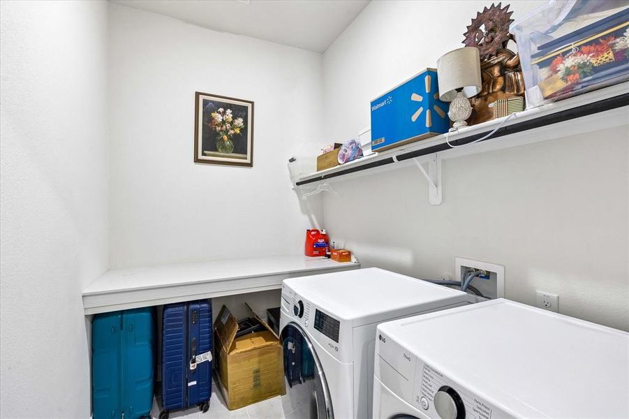 Dedicated laundry area featuring white walls, an integrated countertop, and built-in shelving Dedicated laundry area featuring white walls, an integrated countertop, and built-in shelving
