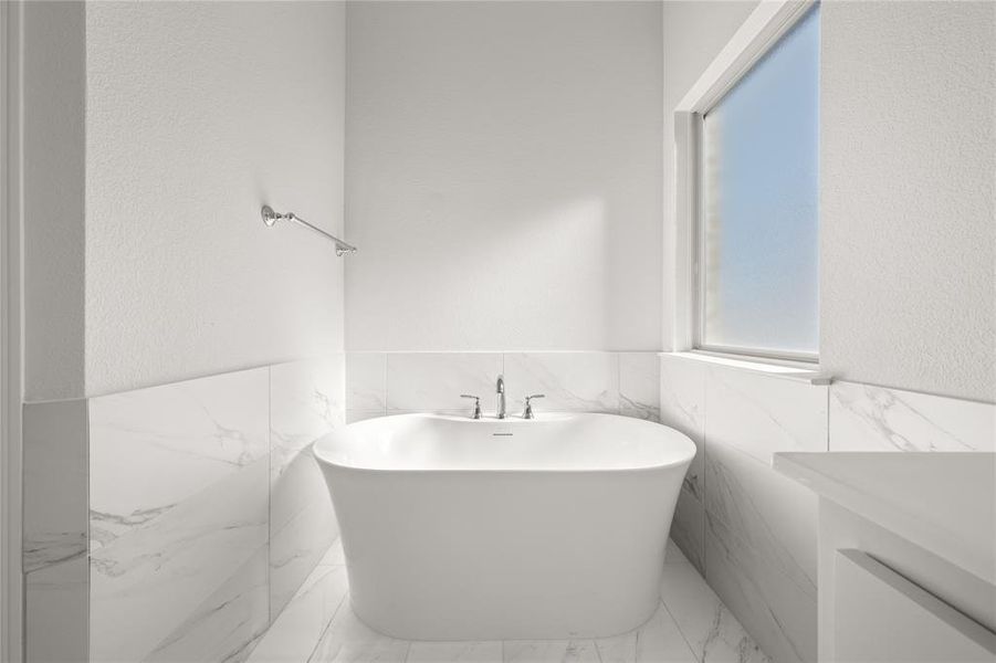 Bathroom featuring a washtub and tile walls