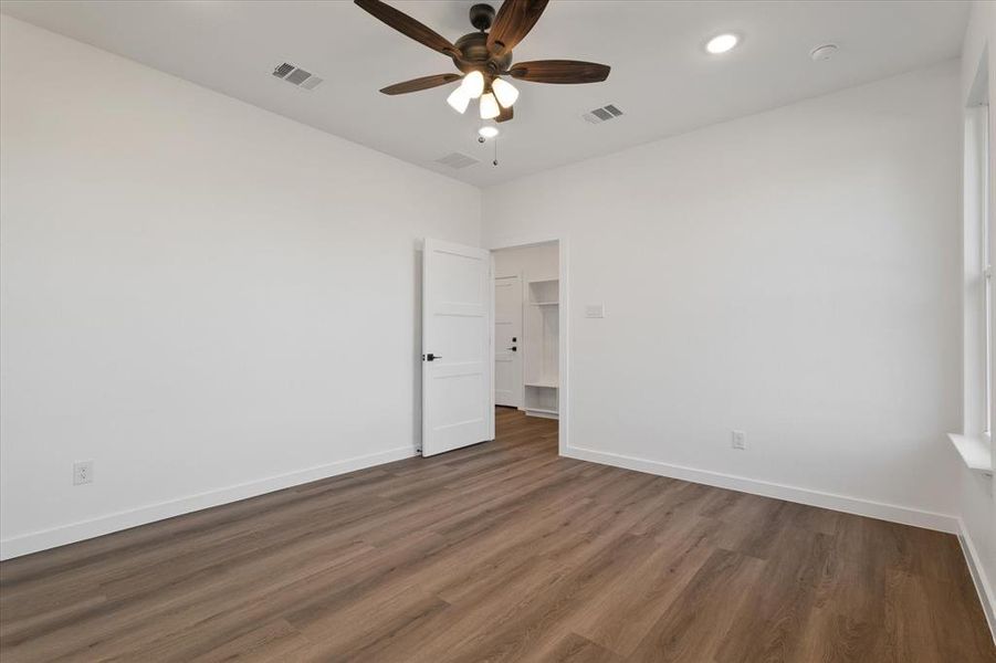 Empty room featuring dark hardwood / wood-style flooring and ceiling fan