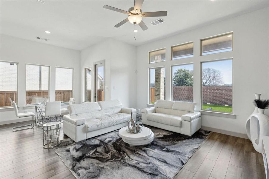Living area featuring recessed lighting, wood finished floors, and a ceiling fan Living area featuring recessed lighting, wood finished floors, and a ceiling fan