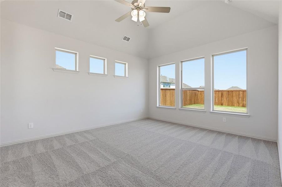 Spacious room with vaulted ceiling and light gray carpet