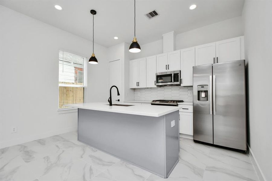 Enhance your culinary prowess in this spacious kitchen with an island providing ample workspace and storage for all your cooking needs.