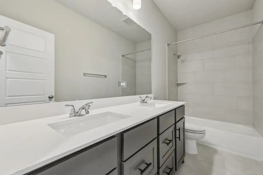 Bathroom with toilet, double vanity, and tub / shower combination Bathroom with toilet, double vanity, and tub / shower combination