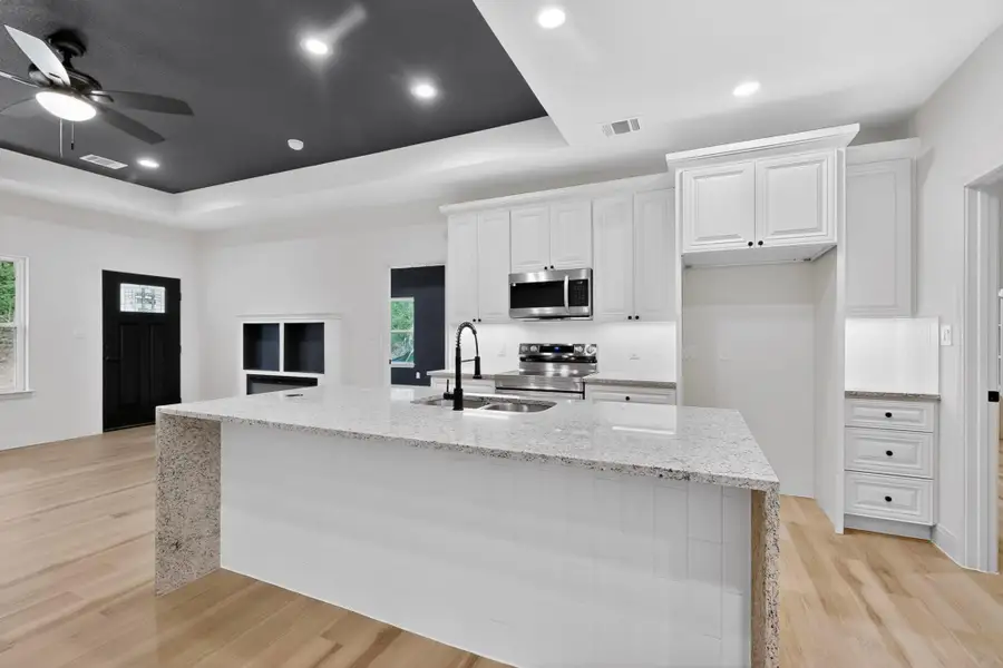 Kitchen island with a light-toned granite countertop and white tile base Kitchen island with a light-toned granite countertop and white tile base