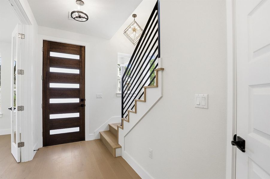 Entryway with light wood finished floors and stairs