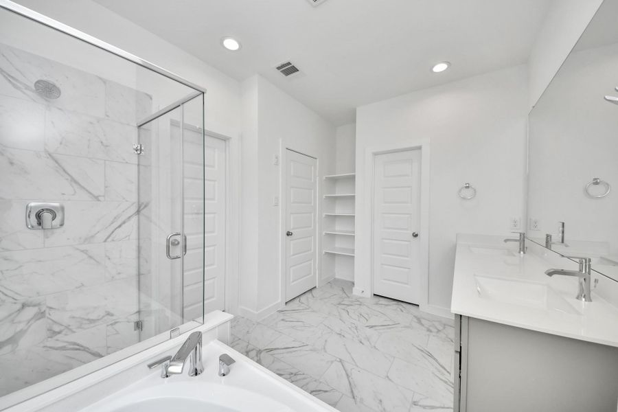 Indulge in a spa-like retreat within the confines of this primary bathroom. Delight in a spacious walk-in shower enveloped in stylish tile surround, unwind in a separate garden tub adorned with custom detailing. Sample photo of completed home with similar floor plan. Actual colors and selections may vary. Indulge in a spa-like retreat within the confines of this primary bathroom. Delight in a spacious walk-in shower enveloped in stylish tile surround, unwind in a separate garden tub adorned with custom detailing. Sample photo of completed home with similar floor plan. Actual colors and selections may vary.