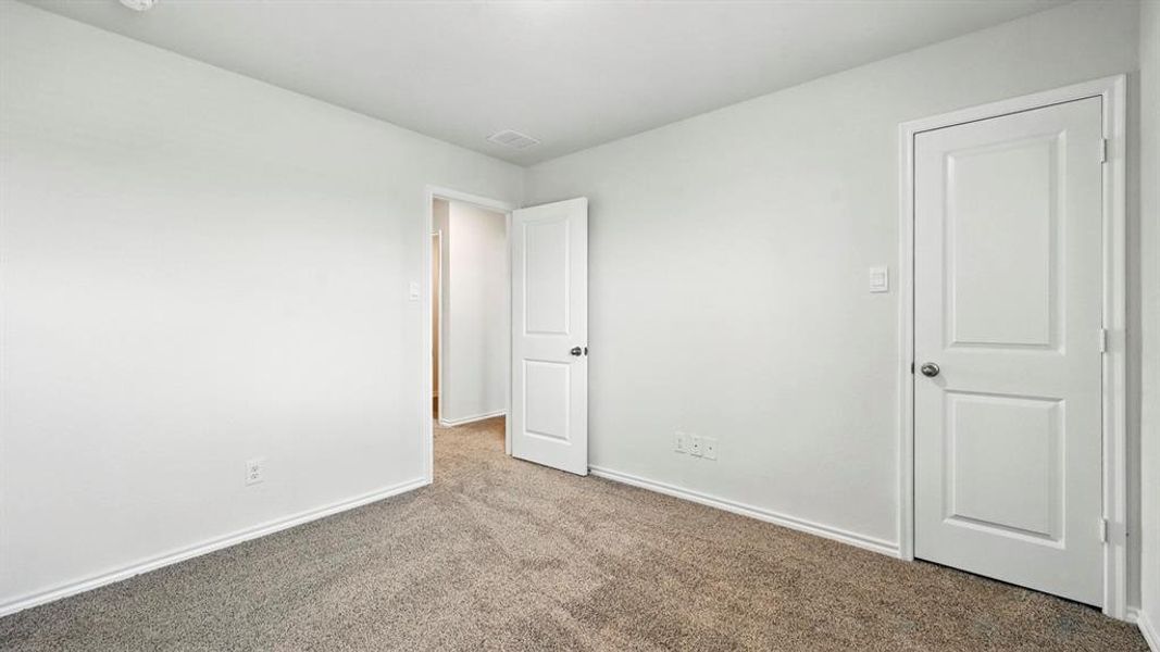 Neutral wall paint, gray carpet flooring, white baseboards, and white two-panel doors