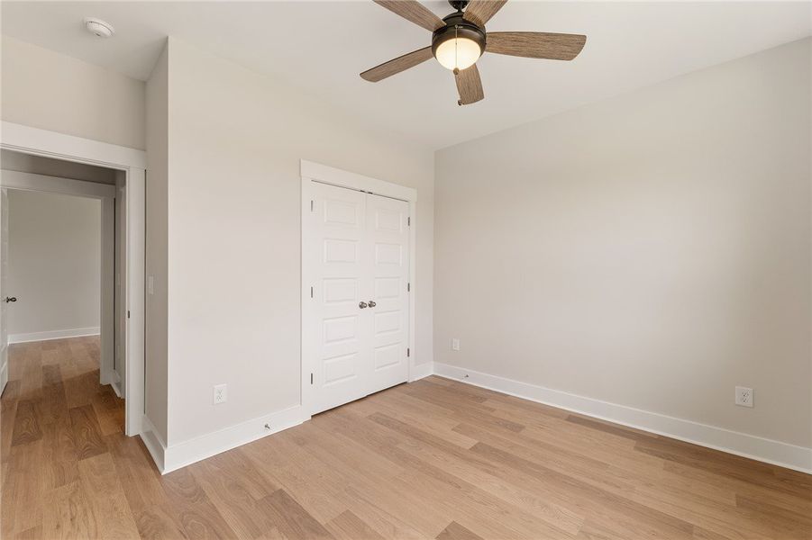 A well-lit bedroom featuring handsome hardwood flo