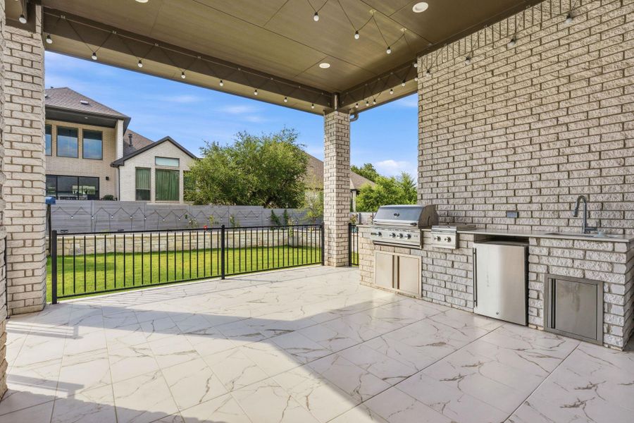 An inviting outdoor kitchen area on a tiled patio, perfect for al fresco dining and entertaining. An inviting outdoor kitchen area on a tiled patio, perfect for al fresco dining and entertaining.