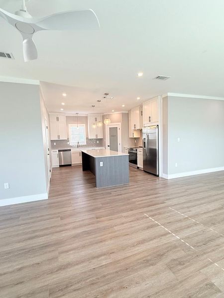 An open-concept design with durable flooring connects the living area to a well-equipped kitchen.