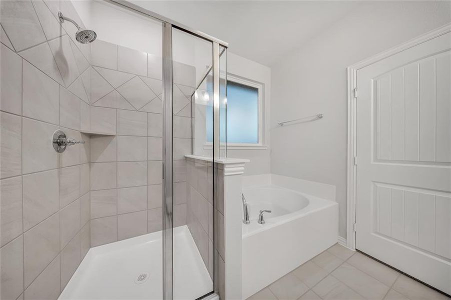 Full bathroom featuring a stall shower, a garden tub, and tile patterned flooring Full bathroom featuring a stall shower, a garden tub, and tile patterned flooring