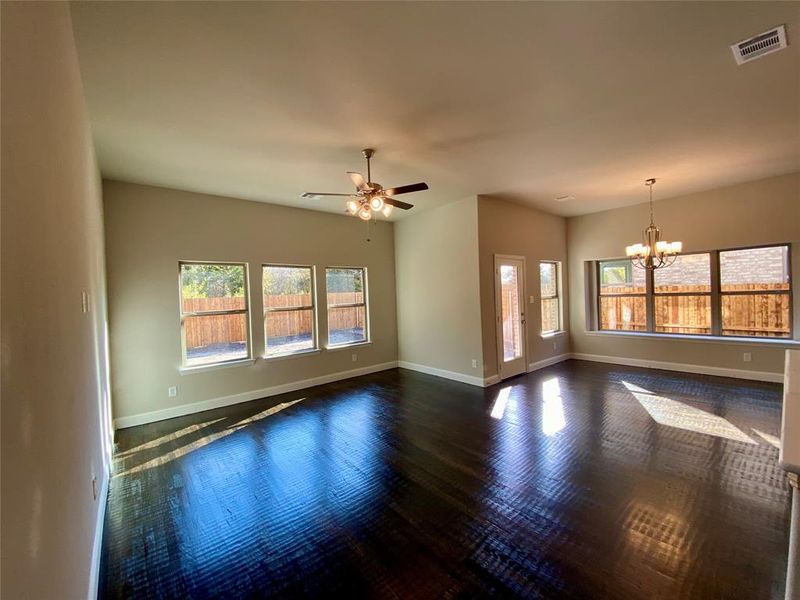 Family room and cafe eating area with ample windows and rich handscraped hardwood floors.