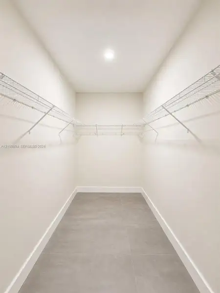 Storage space featuring large-format tile flooring and tiered wire shelving