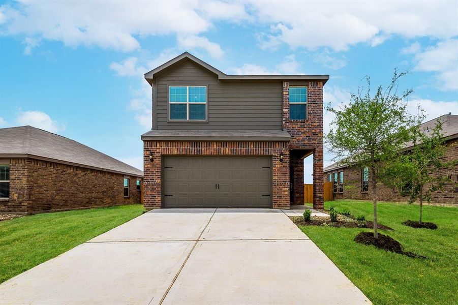 View of front of house with a garage and a front yard