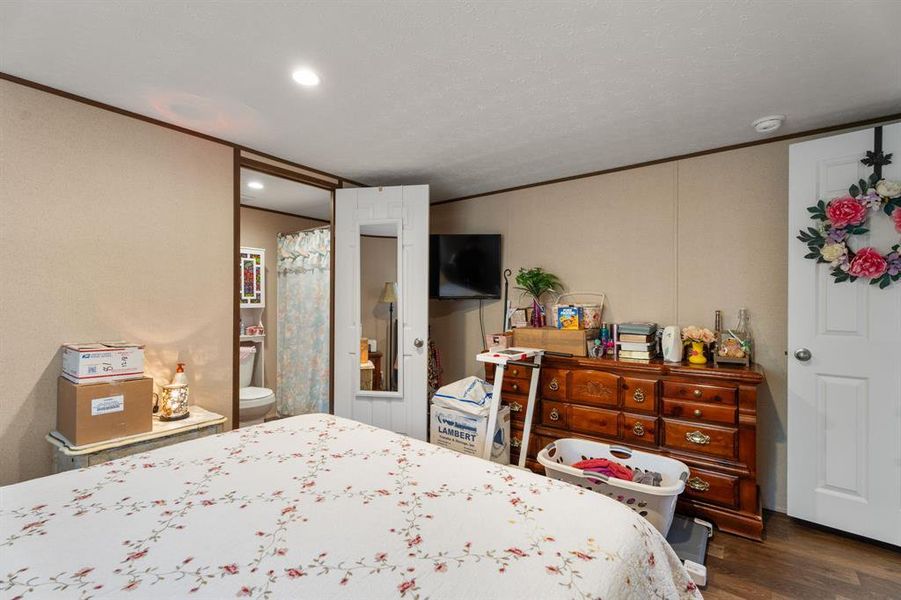 Bedroom with dark wood-type flooring and crown molding Bedroom with dark wood-type flooring and crown molding