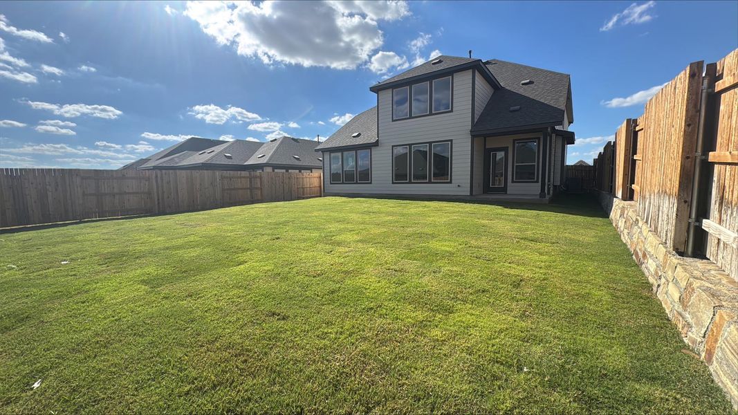 Rear view of property featuring a fenced backyard, a shingled roof, and a patio Rear view of property featuring a fenced backyard, a shingled roof, and a patio