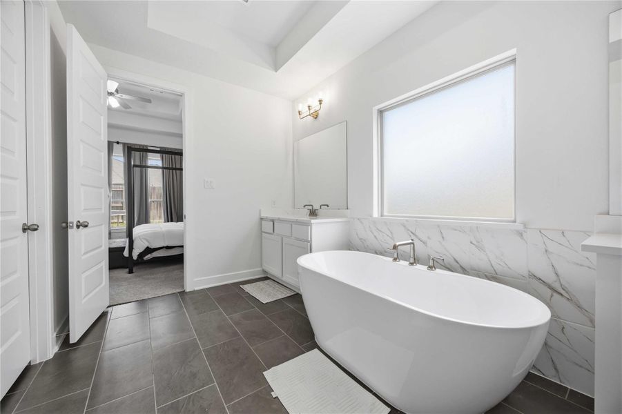 Centered around a freestanding soaking tub, this elegant bath creates the ultimate setting for relaxation and restoration.
