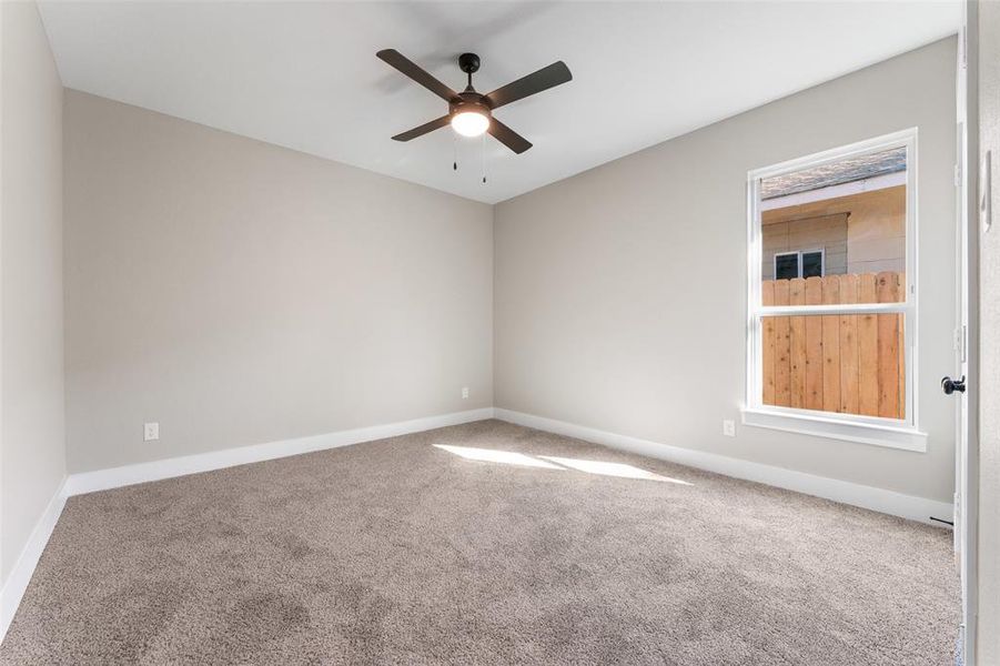 Spare room featuring carpet flooring and ceiling fan