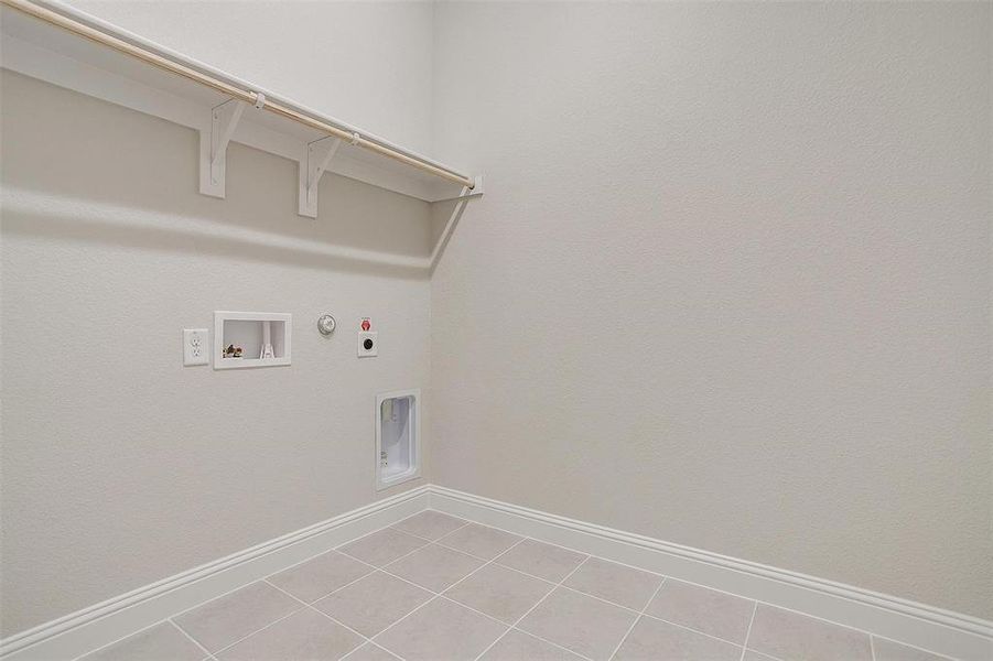 Washroom with washer hookup, gas dryer hookup, light tile patterned floors, and electric dryer hookup