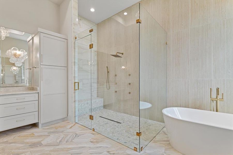 Bathroom with a freestanding bath, a shower stall, vanity, and a chandelier