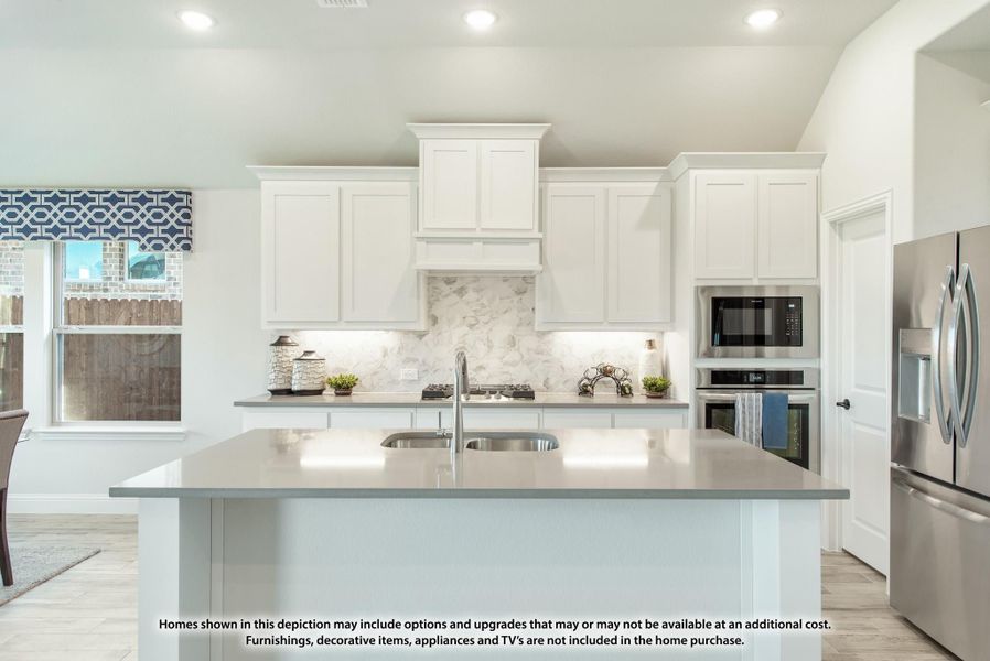 Kitchen with white cabinets, marble backsplash, center island with sink, and stainless steel appliances