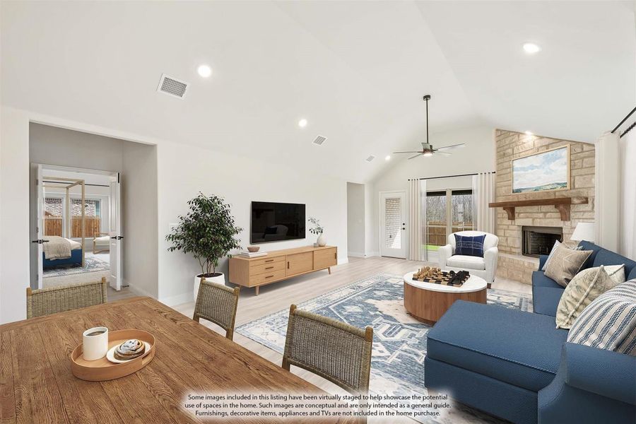Open-concept living room with vaulted ceiling, stone fireplace, and light wood floors
