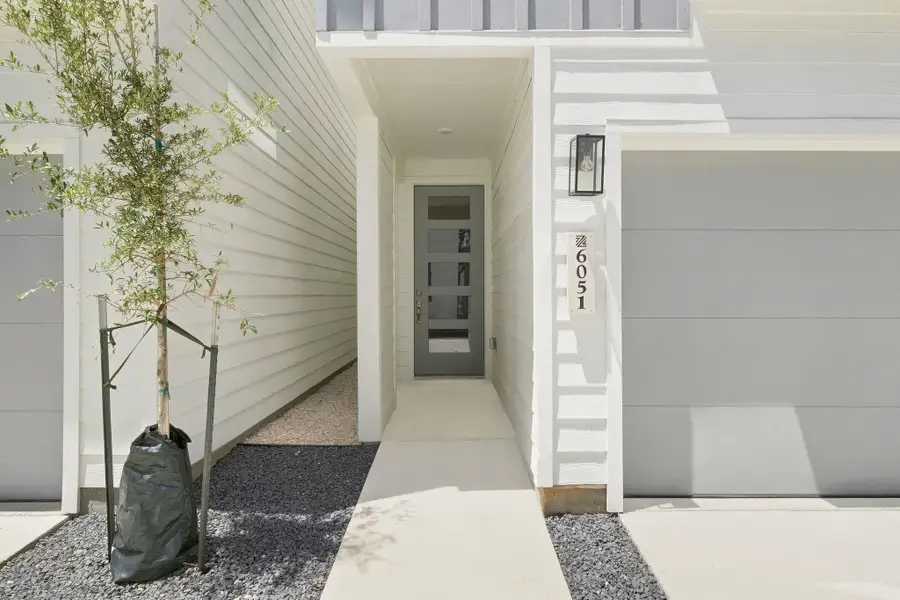 Modern front entry featuring a contemporary glass-panel door, clean architectural details, and exterior lighting. Modern front entry featuring a contemporary glass-panel door, clean architectural details, and exterior lighting.