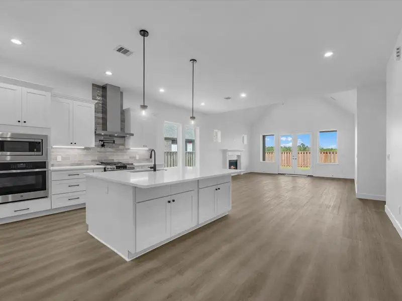 Expansive open concept design, island kitchen w/ white quartz surfaces, and an abundance of cabinetry storage Expansive open concept design, island kitchen w/ white quartz surfaces, and an abundance of cabinetry storage