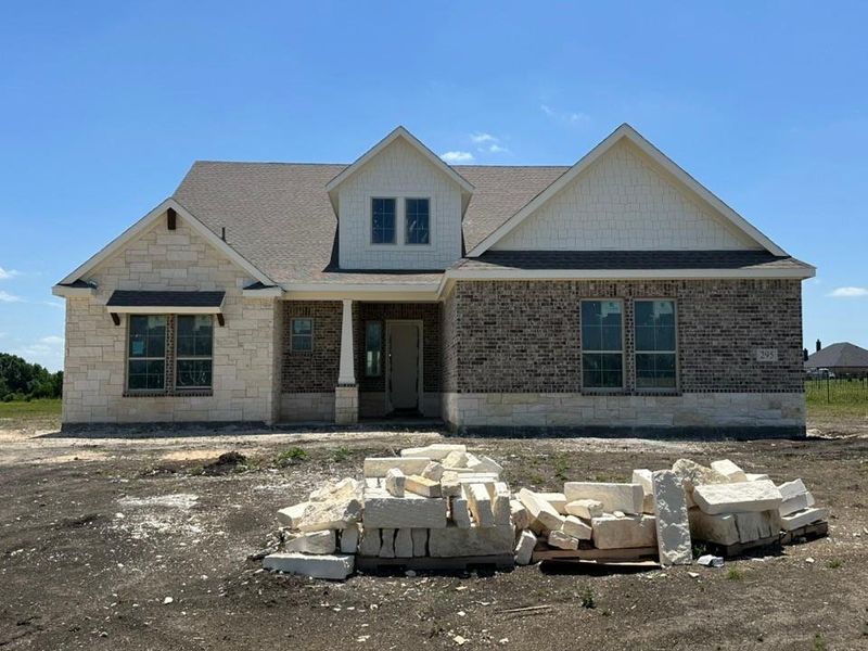 New construction residence featuring a combination of light-colored stone and brick veneer exterior