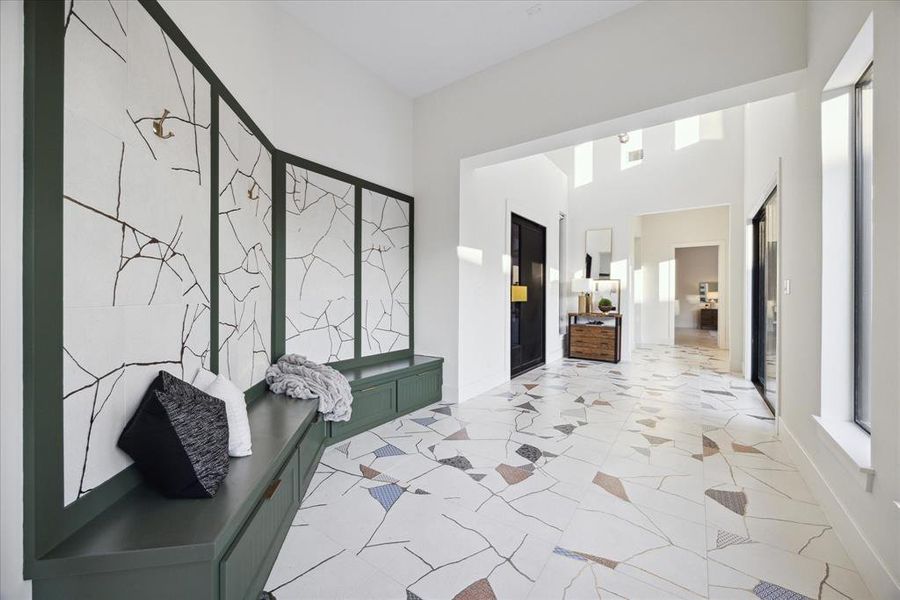 Step into a large foyer bathed in natural light, featuring ample bench space that offers both functionality and a warm, welcoming atmosphere.