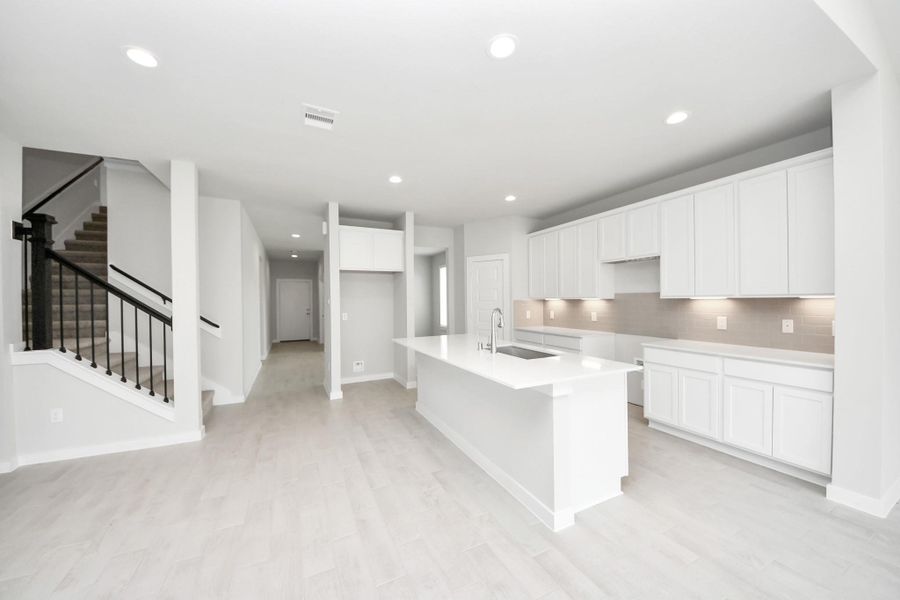 Step into the dream kitchen you've always wanted! This generously spacious culinary haven features a massive granite island, high ceilings, soft-close cabinets, granite countertops, stainless steel appliances, a sleek tile backsplash, and recessed lighting. Step into the dream kitchen you've always wanted! This generously spacious culinary haven features a massive granite island, high ceilings, soft-close cabinets, granite countertops, stainless steel appliances, a sleek tile backsplash, and recessed lighting.