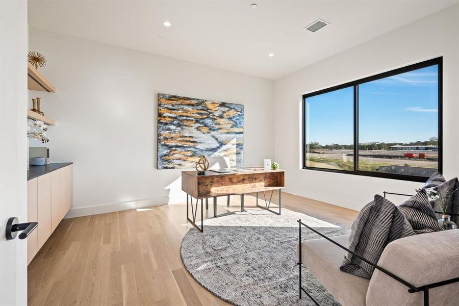 Dedicated home office with floor-to-ceiling windows and serene views. Dedicated home office with floor-to-ceiling windows and serene views.