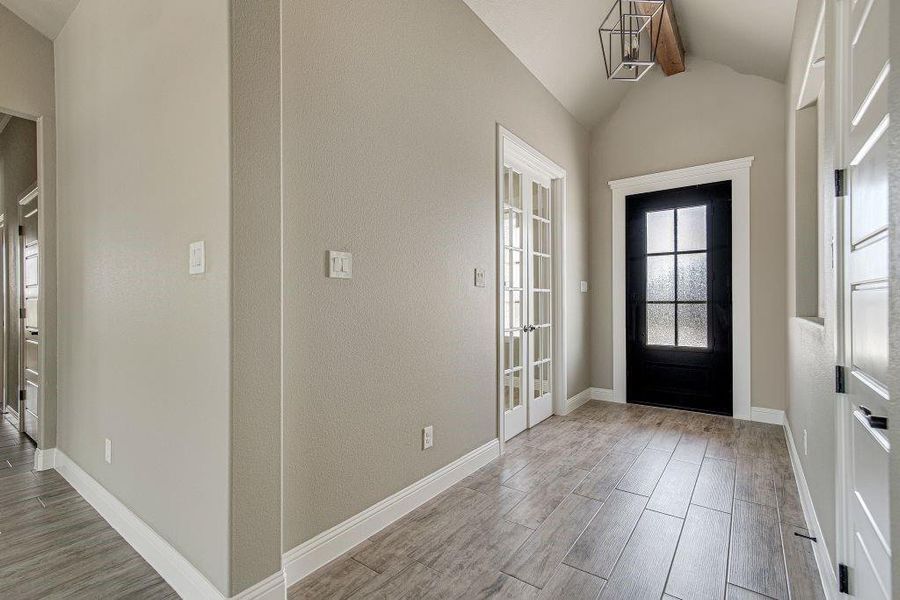 Foyer featuring light hardwood / wood-style flooring and vaulted ceiling