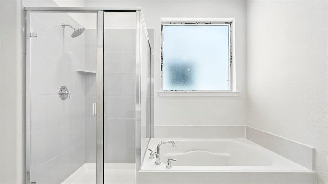 Bathroom featuring a built-in soaking tub with deck-mounted fixtures, a glass-enclosed shower with tile surround and niche, a frosted window, and clean white walls