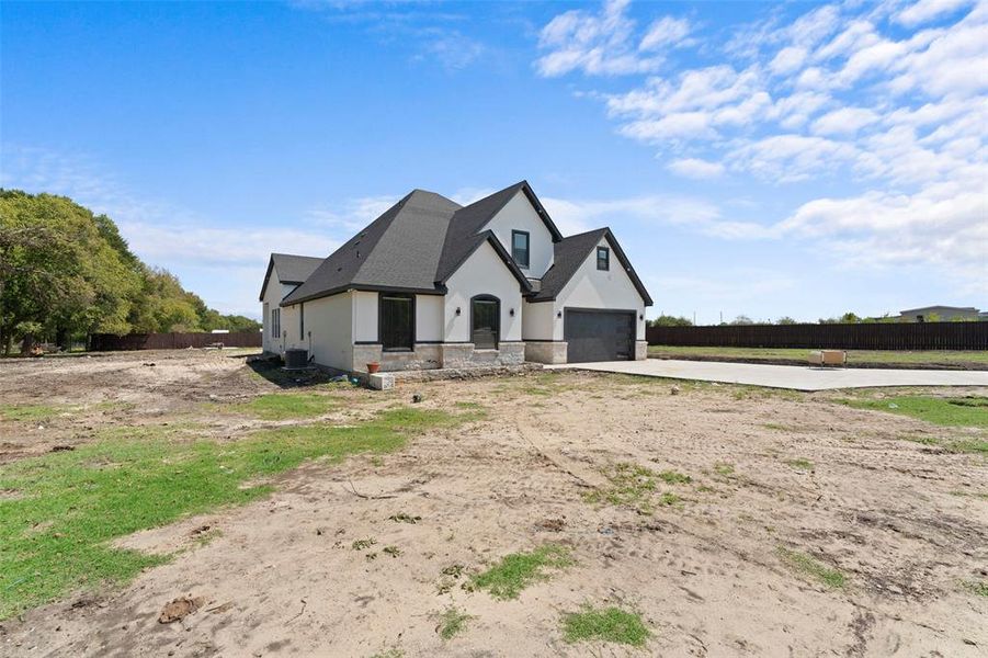 French provincial home with stone siding, stucco siding, driveway, and a garage French provincial home with stone siding, stucco siding, driveway, and a garage