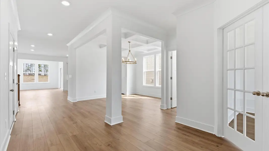 Elegant foyer with hardwood flooring and tasteful trim detail creates a memorable first impression at this home at Foxbank