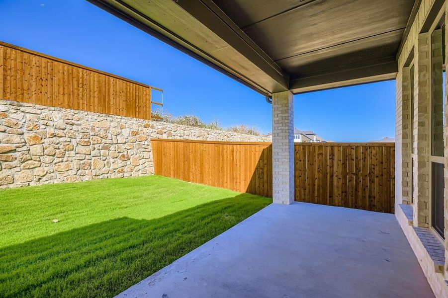 Fenced backyard with a patio