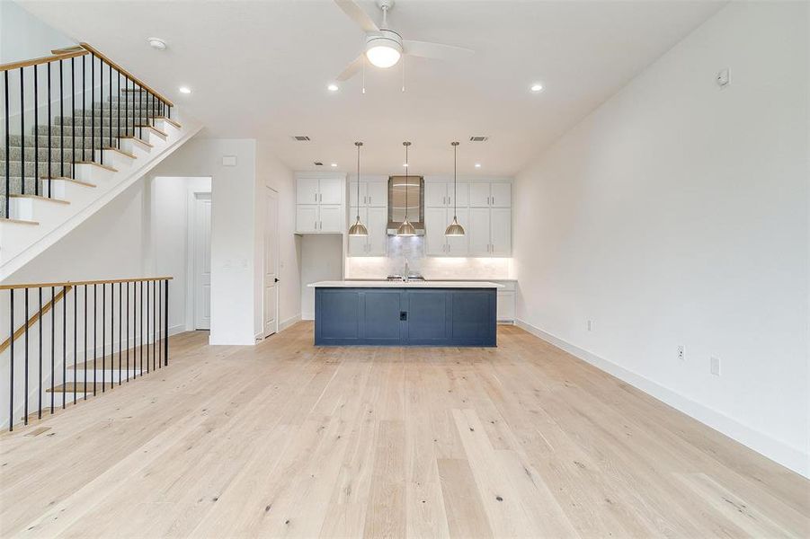 The open kitchen is bathed in natural light from large windows on both sides, creating a bright and welcoming atmosphere.