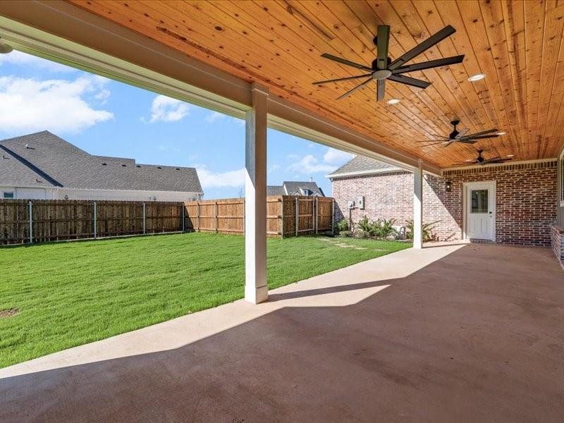 Fenced backyard featuring a patio and a ceiling fan Fenced backyard featuring a patio and a ceiling fan