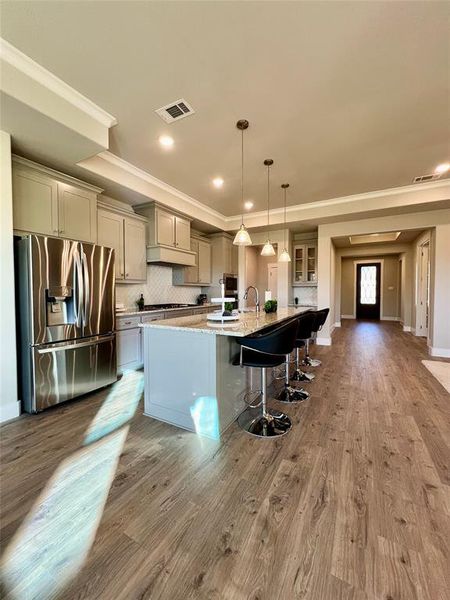 Beautiful Kitchen to be proud of featuring light granite countertops, an over sized kitchen island with S.S. sink,  All  S.S appliances, gas cook top,  luxury plank floors and grey cabinet all completed October 16, 2024.