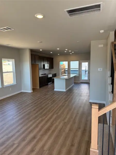 Kitchen featuring dark brown cabinets, recessed lighting, a center island with sink, healthy amount of natural light, and range Kitchen featuring dark brown cabinets, recessed lighting, a center island with sink, healthy amount of natural light, and range