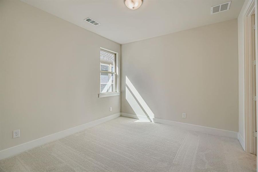 Spare room with light colored carpet and baseboards