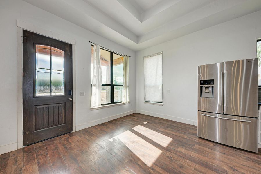 Rich wood floors and a tray ceiling define this light-filled entry space.
