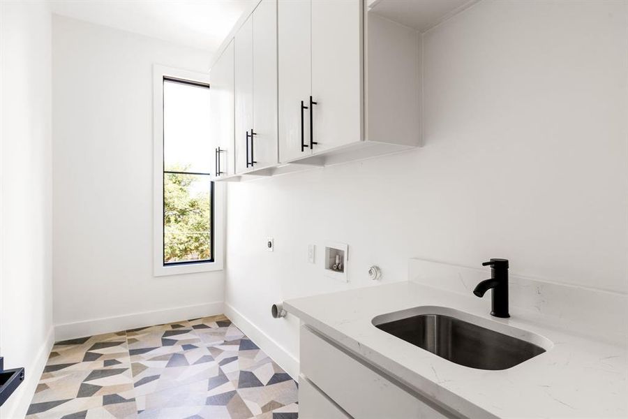 Washroom with cabinet space, hookup for an electric dryer, washer hookup, and light floors Washroom with cabinet space, hookup for an electric dryer, washer hookup, and light floors