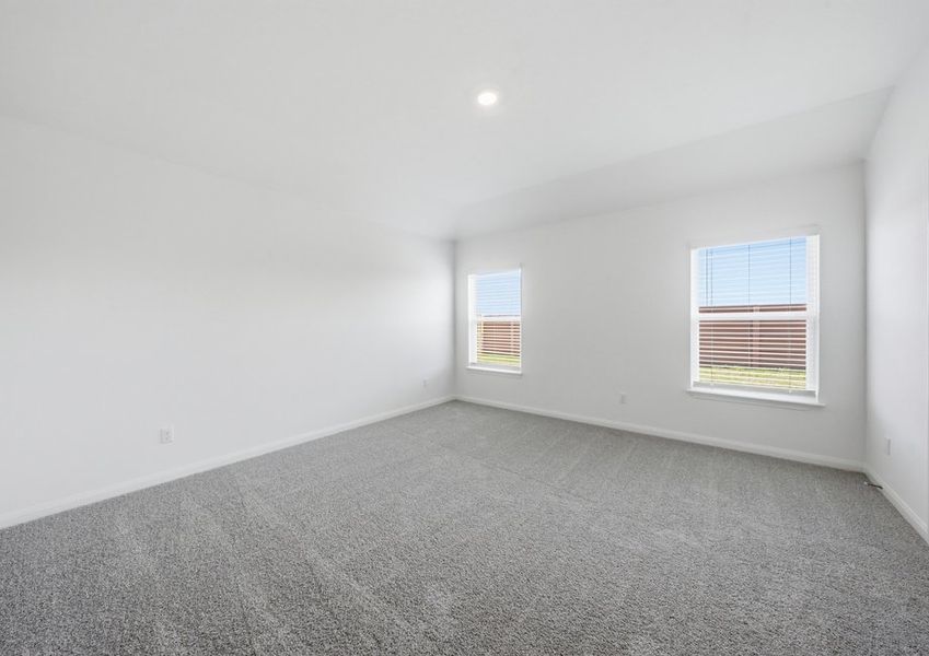 Spacious carpeted primary bedroom featuring windows with natural light. Spacious carpeted primary bedroom featuring windows with natural light.