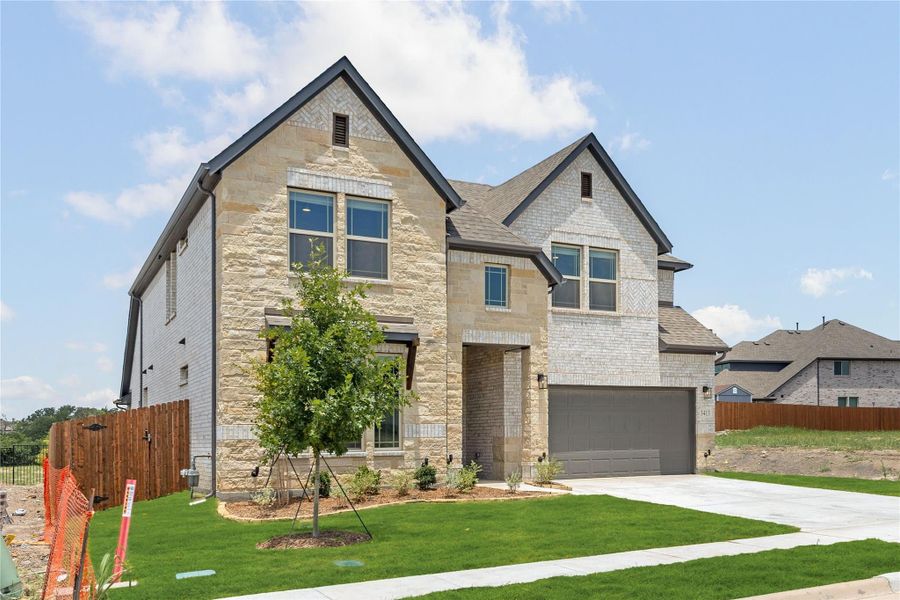 Two-story home with stone and brick exterior, two-car garage, and landscaped front yard Two-story home with stone and brick exterior, two-car garage, and landscaped front yard