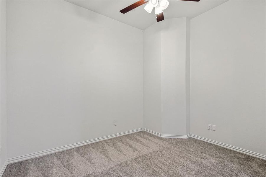 Carpeted empty room featuring ceiling fan