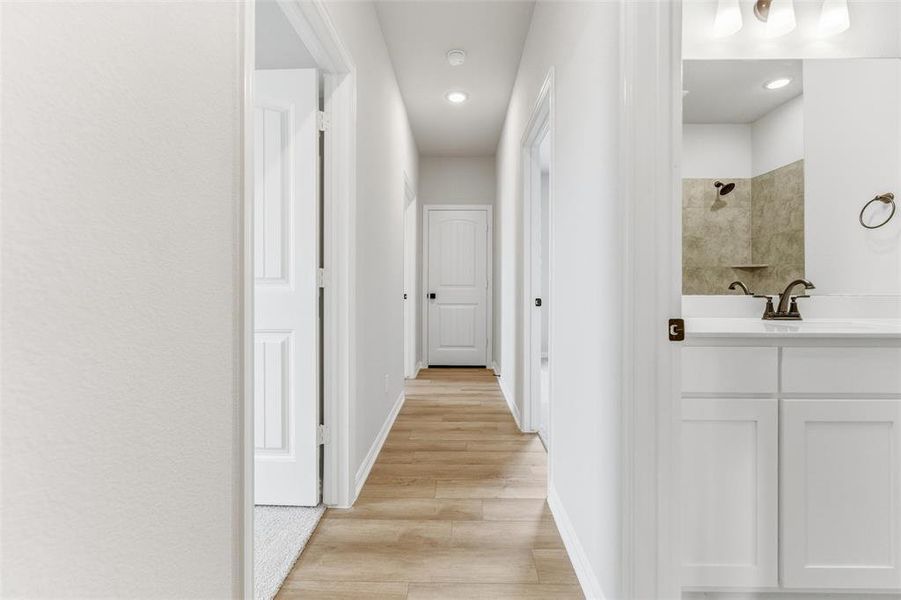 Hall featuring light wood-type flooring and recessed lighting